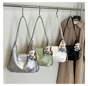 Detail view of stylish leather shoulder bags in four colors with cute teddy bear charms