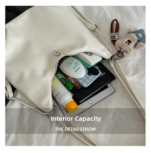Overhead view showing large capacity interior of the white leather tote with daily essentials
