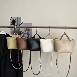 Detail view of colorful leather tote bags hanging in five elegant minimalist color options