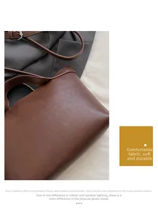 Detail of a brown leather tote bag with natural texture and adjustable shoulder straps
