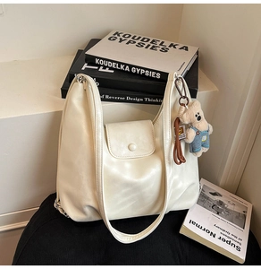 Detailed macro view of the cream white PU leather tote with a cute bear charm accessory