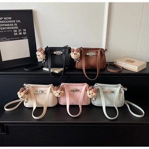 Close-up of minimalist leather handbags in five colors with cute bear charm and silver lock