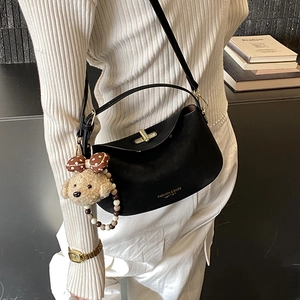 Chic black matte leather shoulder bag with golden logo and cute teddy dog charm