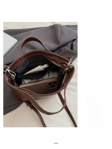 Top view of spacious brown tote bag interior with zipper pocket, phone, and cosmetics