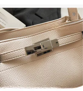 Detail of lychee pattern leather handbag featuring silver metallic turn-lock closure