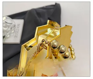 Close-up of golden geometric evening bag showing premium hardware and bead handle
