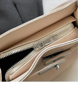 Detail of lychee pattern leather texture with silver metal zipper and sleek twist lock