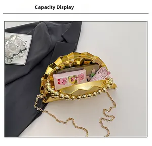 Detail view of gold shell evening clutch with pearl handle showing interior capacity