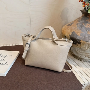 Detail of light beige PU leather tote bag with silver buckle and adjustable strap