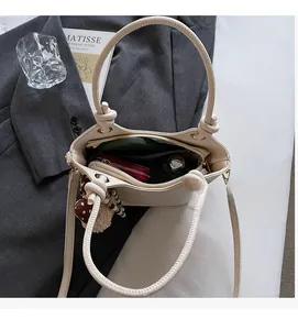 Bovenaanzicht van beige emmertas met ruime binnenkant voor telefoon en portemonnee