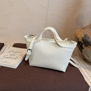 Detailed macro view of the cream white PU leather tote bag with elegant silver hardware