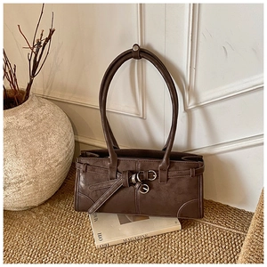 Vue détaillée d'un sac d'épaule vintage marron foncé avec une boucle de ceinture élégante
