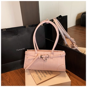 Gros plan d'un sac porté épaule en cuir rose avec boucles métal et longues anses