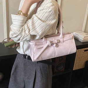 Détail du sac à bandoulière rose avec boucles argentées et sangle en similicuir sur modèle