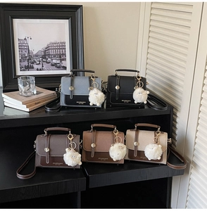 Detail showing five assorted stylish PU leather crossbody bags with plush ball charms