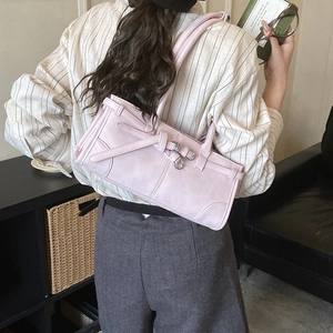 Gros plan du sac à bandoulière rose avec boucles en métal argenté et détails de sangles