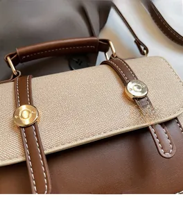 Close-up of dual-tone leather and fabric texture with golden buckle on the bag