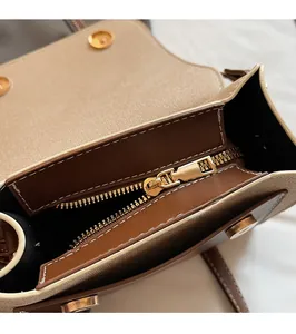 Detail of premium gold metal zipper and two-tone leather trim on crossbody square bag