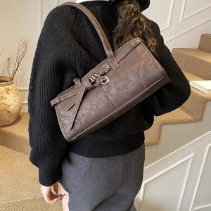 Détail d'un sac cabas vintage marron foncé avec boucles argentées et cuir PU texturé de luxe
