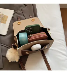 Detail view of spacious inner compartment of the chic beige and brown crossbody bag