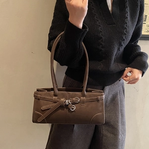 Détail du sac à main en cuir mat marron foncé avec boucle vintage et anneaux élégants