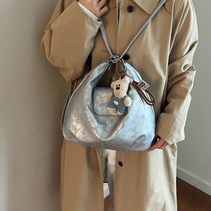 Silver crescent hobo shoulder bag with metallic finish and cute plush bear charm
