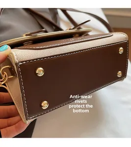 Detail of purse base with protective gold studs and premium brown leather stitching