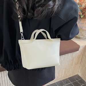 Detail of cream PU leather tote bag with silver metal hooks and fine stitching