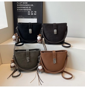Détail de quatre sacs seaux colorés avec boucles métalliques argentées et breloque poney