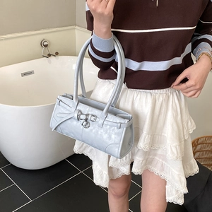 Détail d'un sac à bandoulière en similicuir bleu clair avec lanières et boucles métalliques