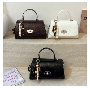 Detailed view of vintage crossbody bags in brown, white, and black with beaded charms