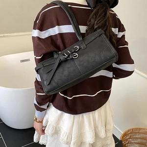 Vue détaillée du sac à bandoulière vintage noir avec boucles métalliques sur un mannequin