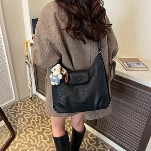 Model view showing the back profile and drape of the black PU leather hobo bag