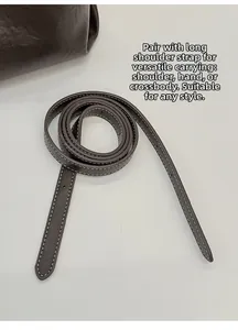 Detail of dark brown lychee grain leather shoulder strap with contrast white stitching