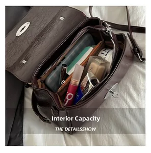 Top view of deep red crossbody bag interior with lipstick, foundation, and skincare