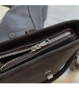 Vue détaillée de la fermeture éclair argentée et du fermoir sur un sac seau brun