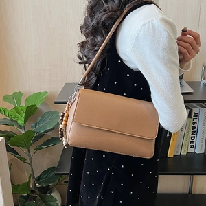 Borsa a spalla in pelle marrone a grana litchi con ciondolo decorativo in perle di legno