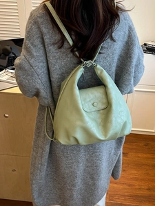 Minimalist mint green faux leather backpack with metallic knot strap and flap closure