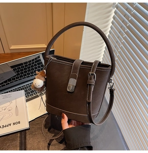 Détail d'un sac seau vintage marron avec bijou de sac cheval et bandoulière réglable