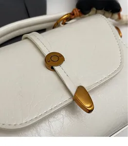 Detailed macro view of cream wrinkled leather texture and vintage gold hardware buckle