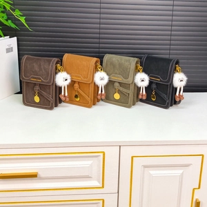 Detail view of small crossbody phone bags in four colors with plush doll pendants