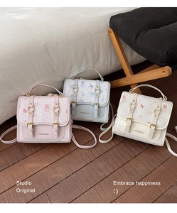 Detailed close-up of cute textured backpacks in pink, blue, and white with bow patterns