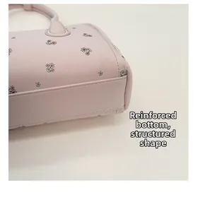 Detail of reinforced bottom stitching on light pink floral print faux leather handbag