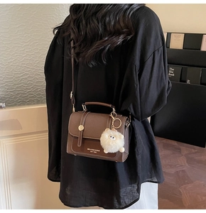 Lifestyle view of brown vintage PU leather crossbody bag with a plush lamb charm pendant