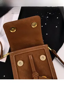 Detail of magnetic snap closure on brown pebbled faux leather crossbody phone bag