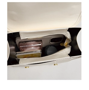 Interior view of beige commuter bag showing storage space for phone and cosmetics