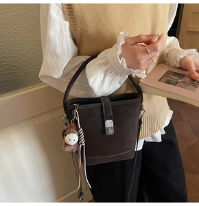 Détail du sac seau marron café avec fermoir rotatif argenté et bordure tressée