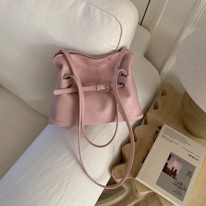 Detail of light pink pleated tote bag with decorative strap buckle on soft PU leather