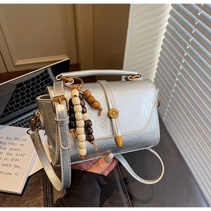 Silver metallic leather crossbody bag with vintage gold hardware and wooden beads detail