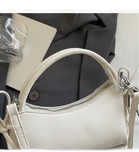 Detalle del asa lisa y la cremallera plateada en un bolso chic de cuero sintético